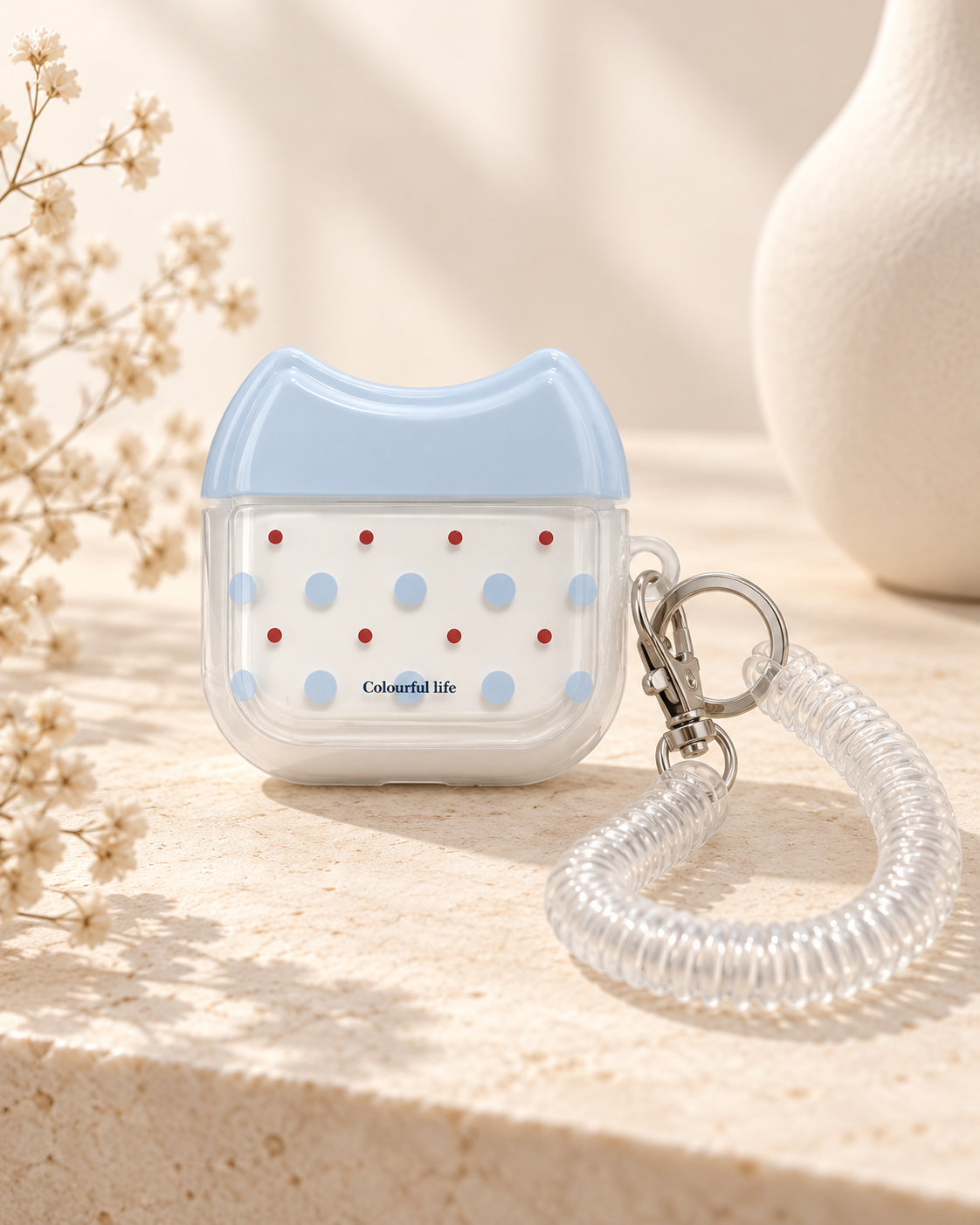 Clear cat ear AirPods 4 case with red and white polka dots and a coiled wrist strap